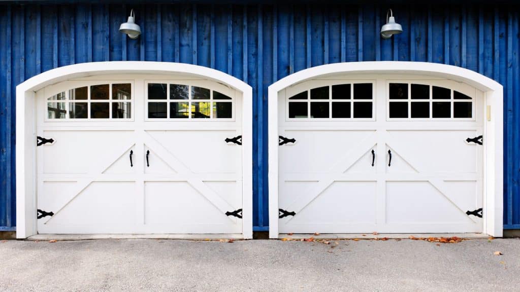 Carriage-style doors with black hardware and garage door decor 